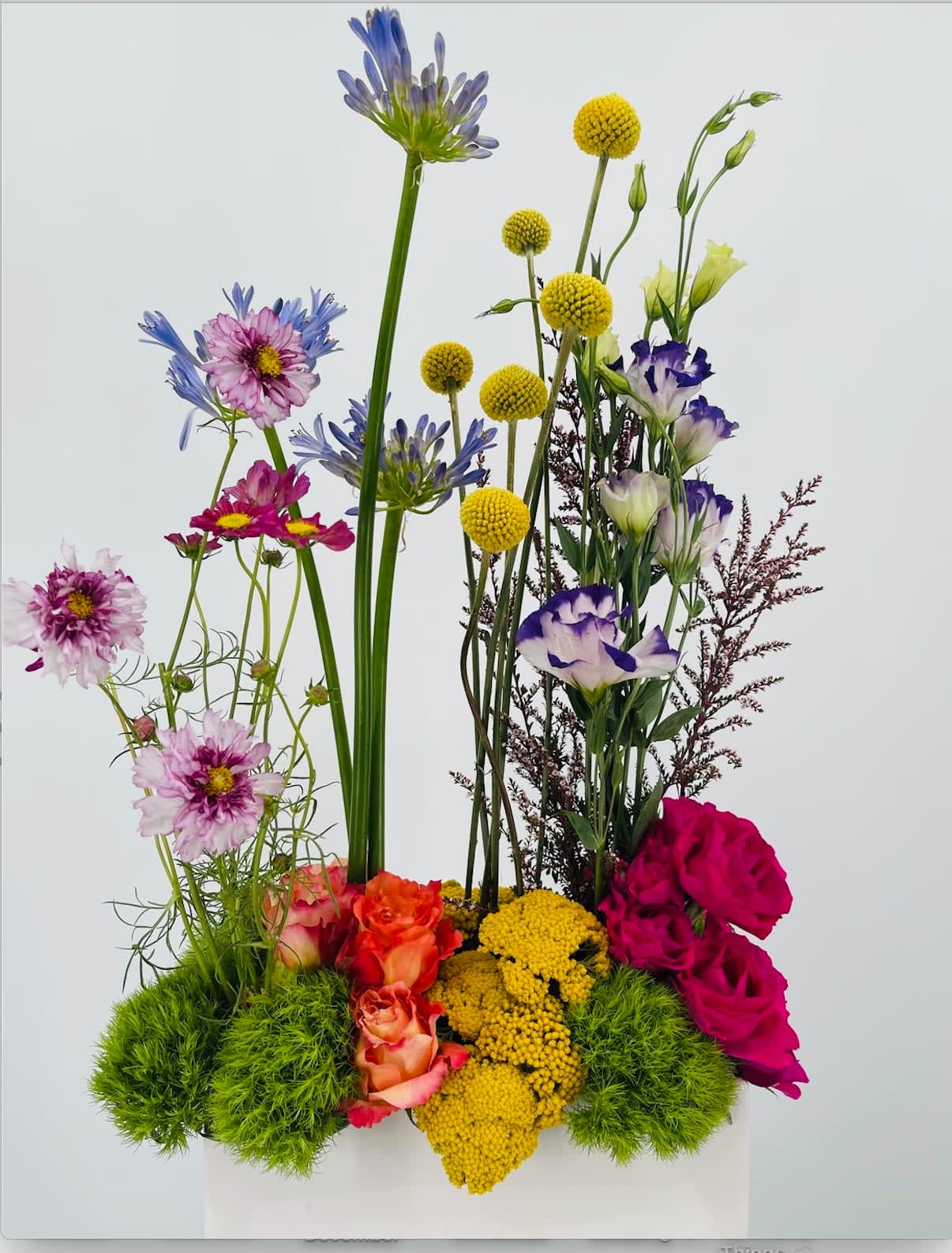 Andrea - Fun, whimsical and bright are what you get with this beautiful floral in a rectangle white ceramic vase. 