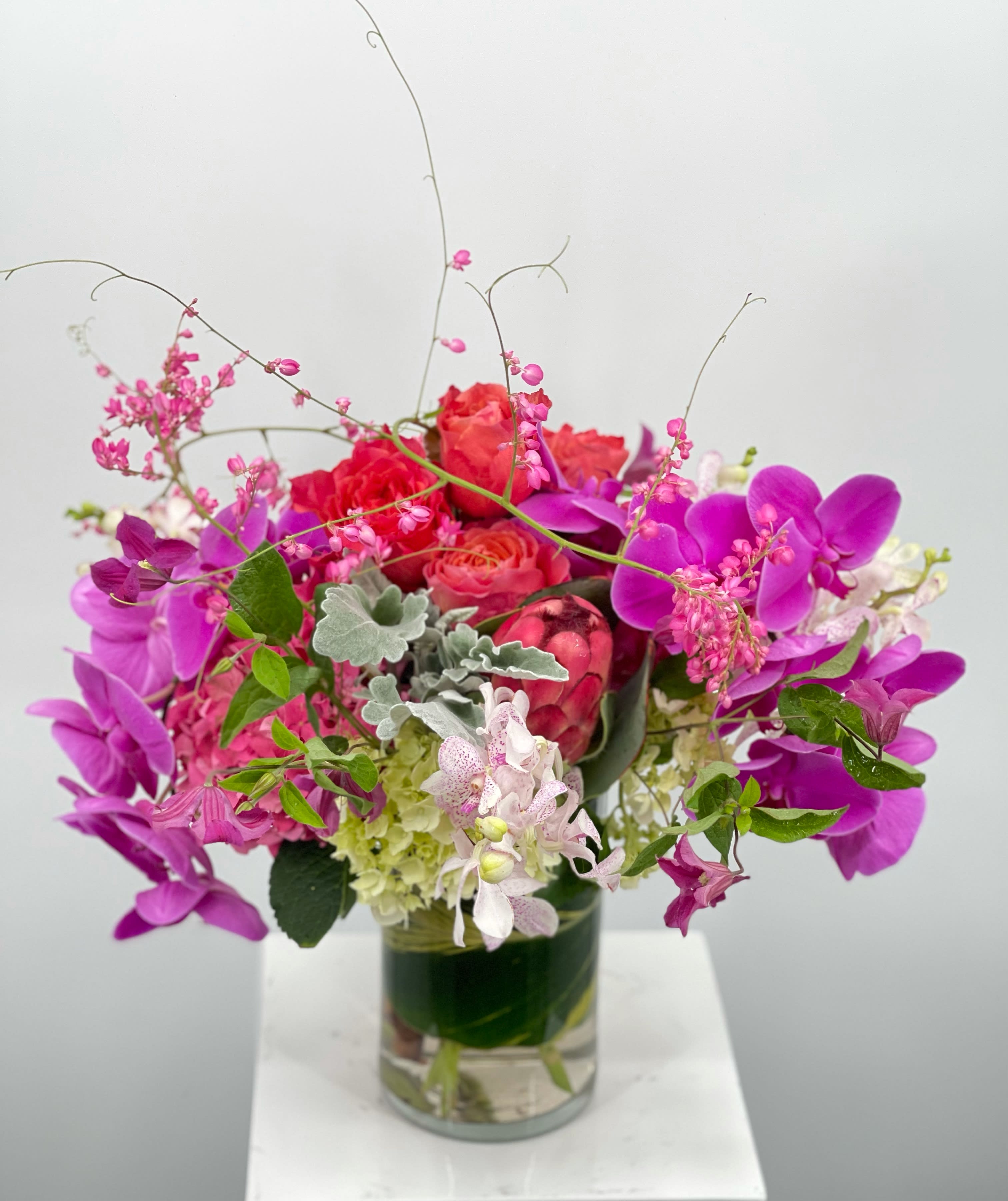 Roxy  - Lush, moody and textured florals sure to make a statement accented with orchids. 
