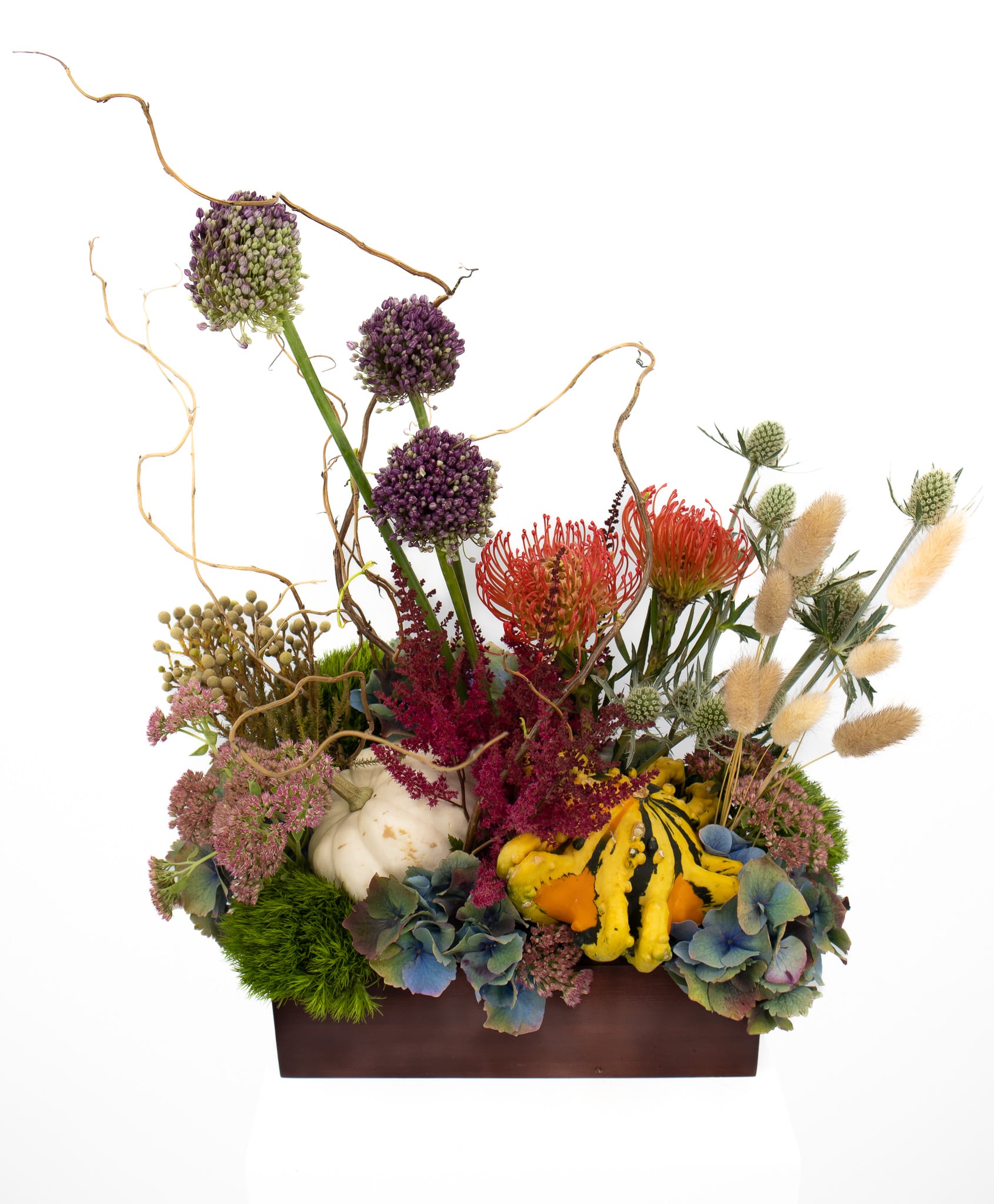 Nolan - A fun piece to give any room or space a little Fall/Autumn feel. Made with beautiful Allium, Protea, Sedum, Pumpkins &amp; Willow twigs. This arrangement is sure to provide all the "FALL Vibes" we could hope for. 