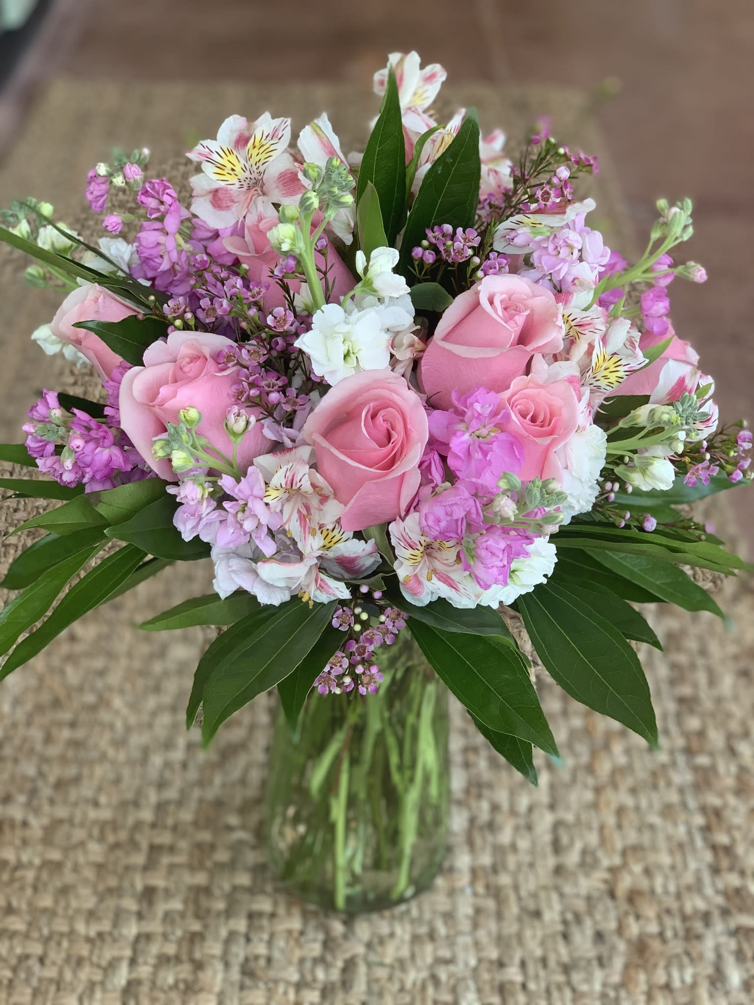 Pink roses and mixed pink-white flowers in a glass vase