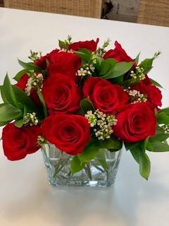 Red roses arranged in a clear glass vase