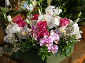 Pink and white floral arrangement in a green container