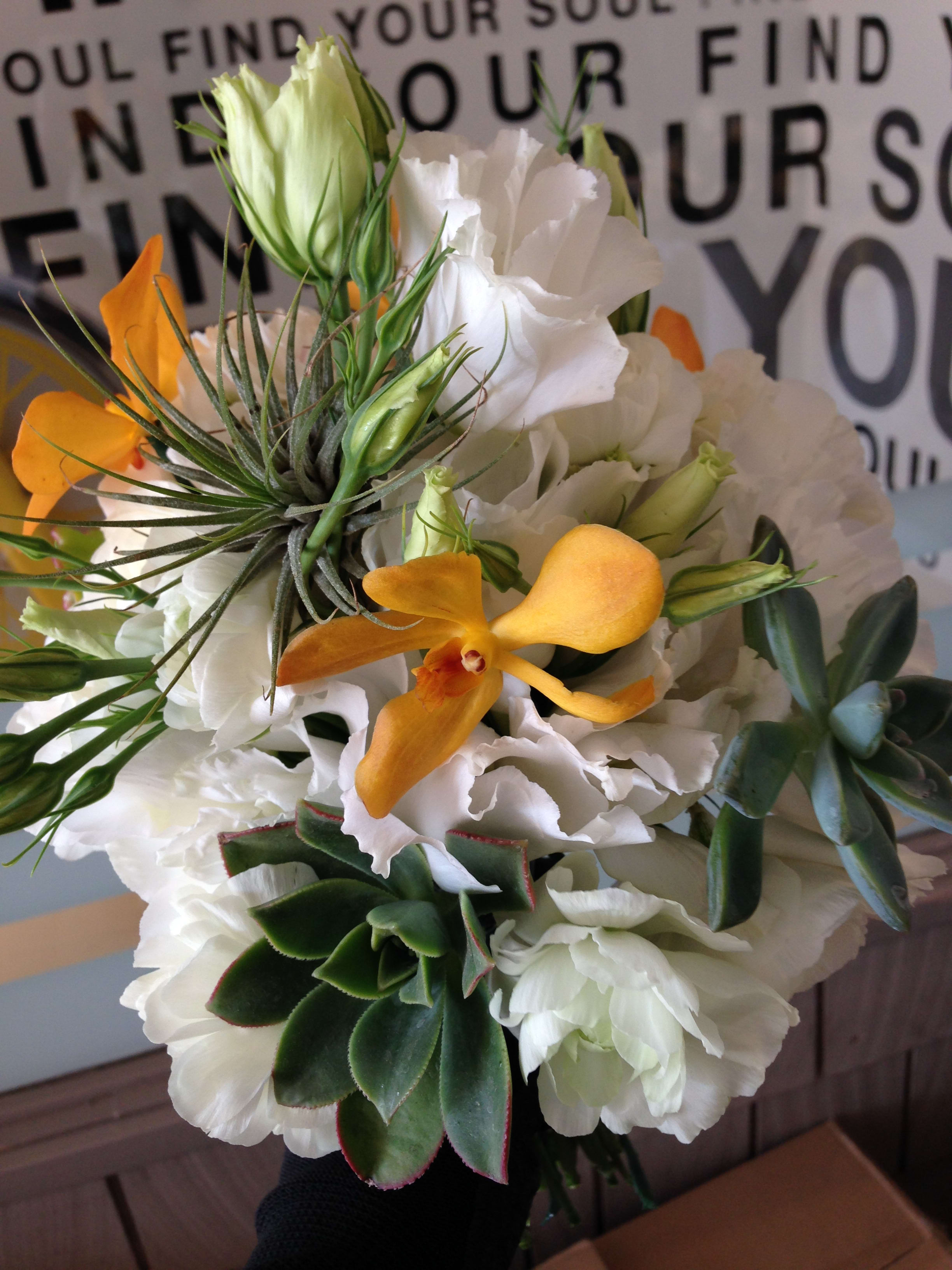 Bouquet of white flowers with orange orchids and succulents