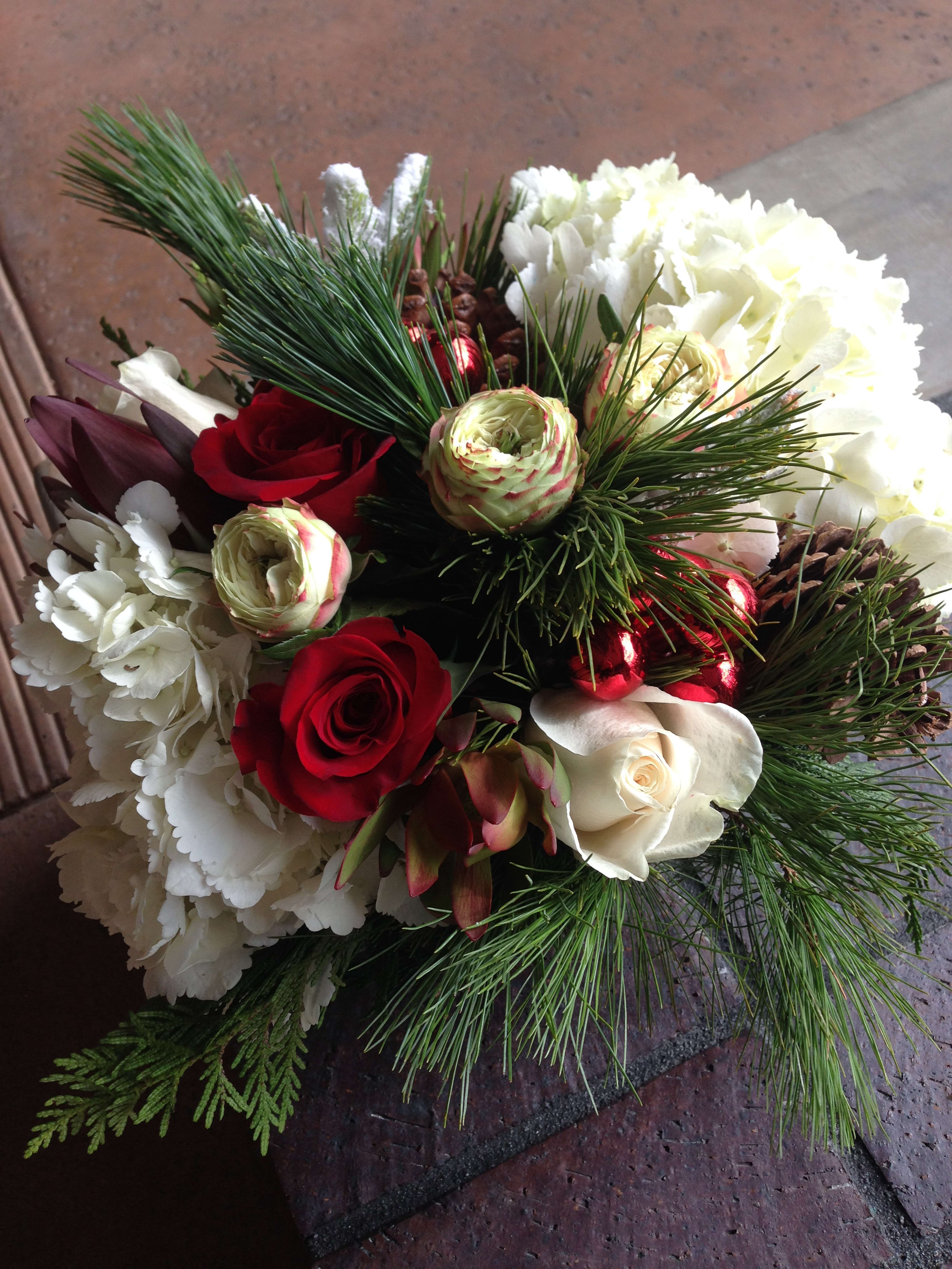 Bouquet of red and white roses with pine branches and pinecones