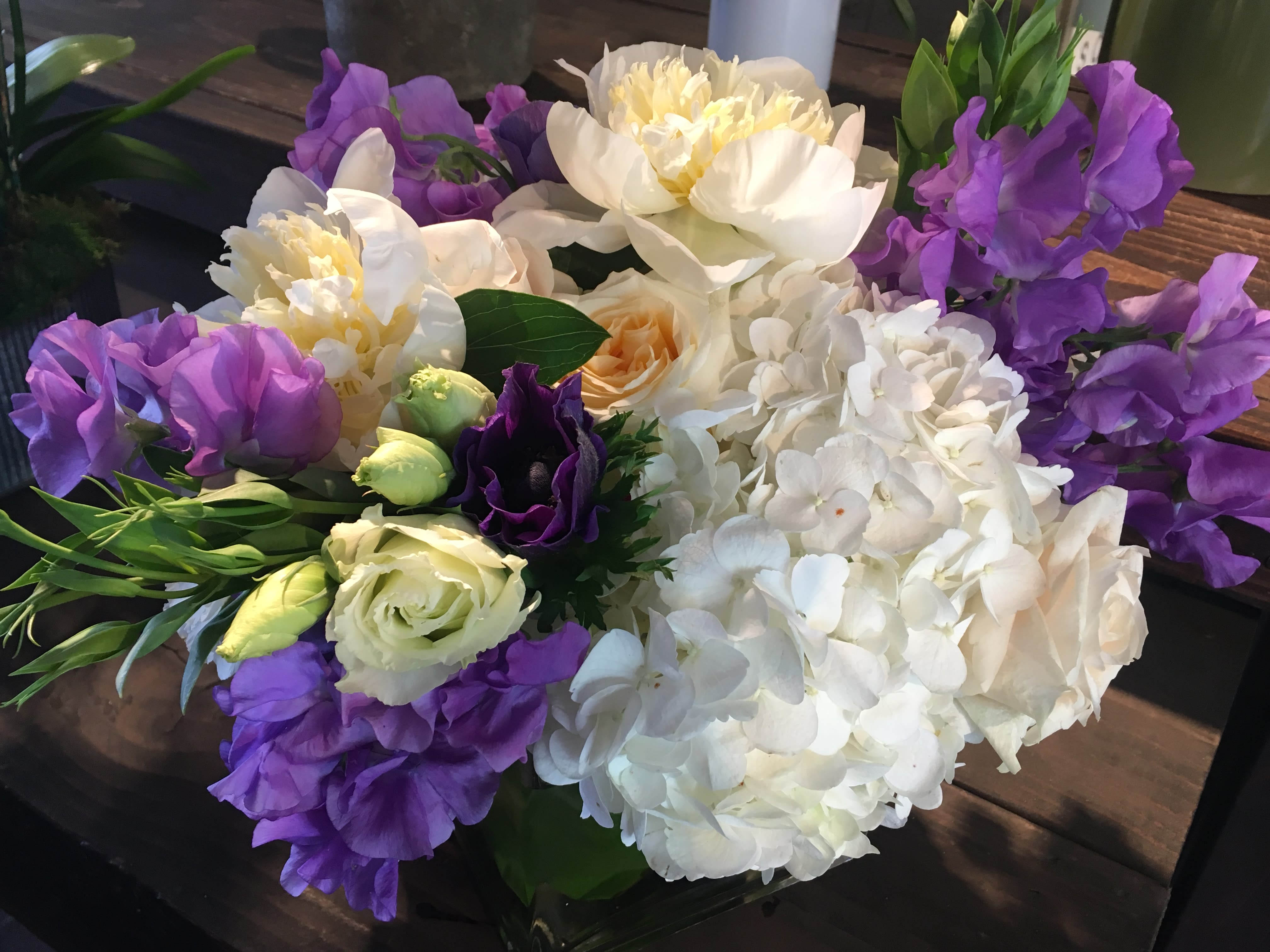 Bouquet of white hydrangeas, purple blooms, and cream roses