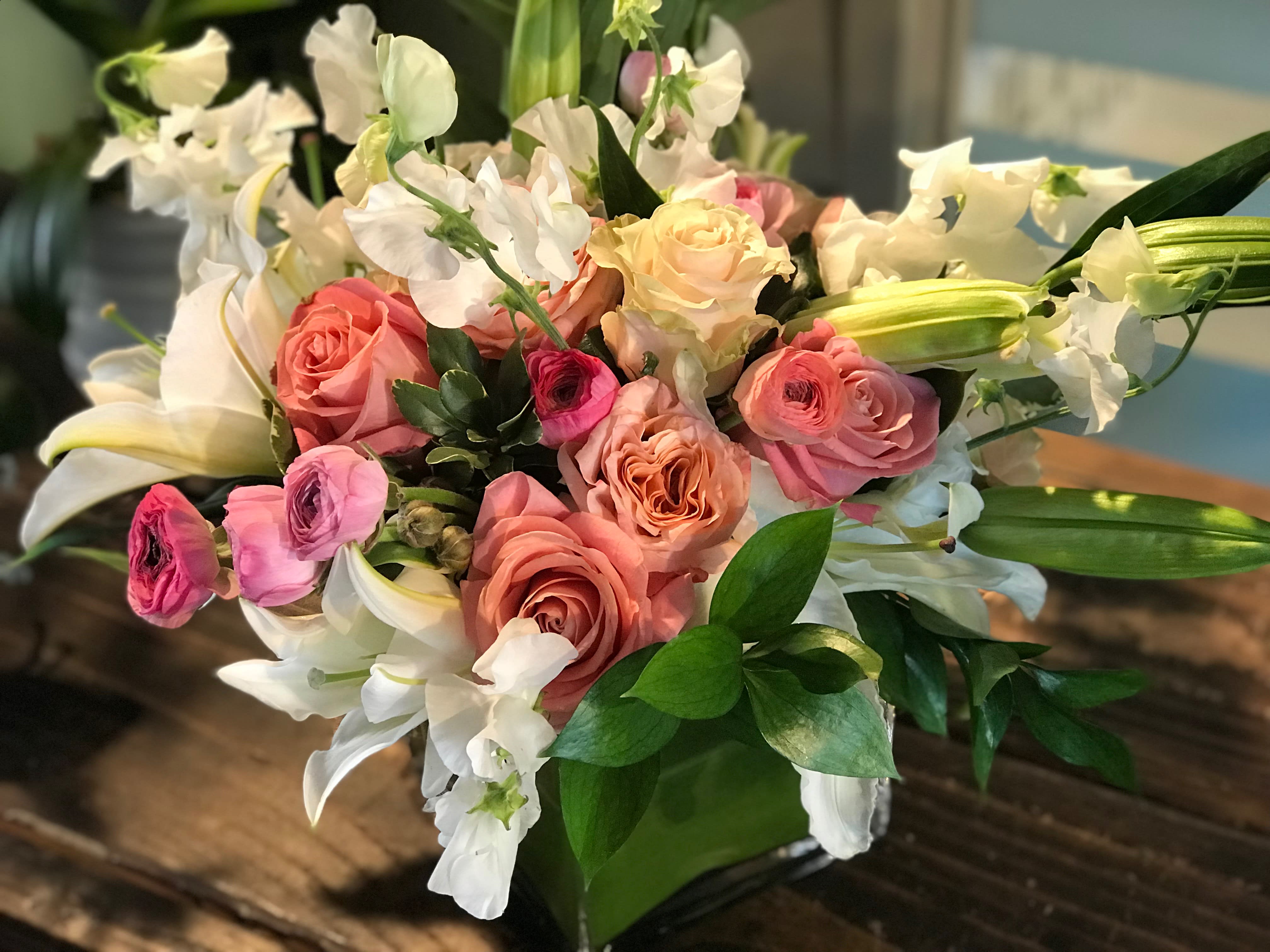 Bouquet of pink and peach roses with white lilies and orchids