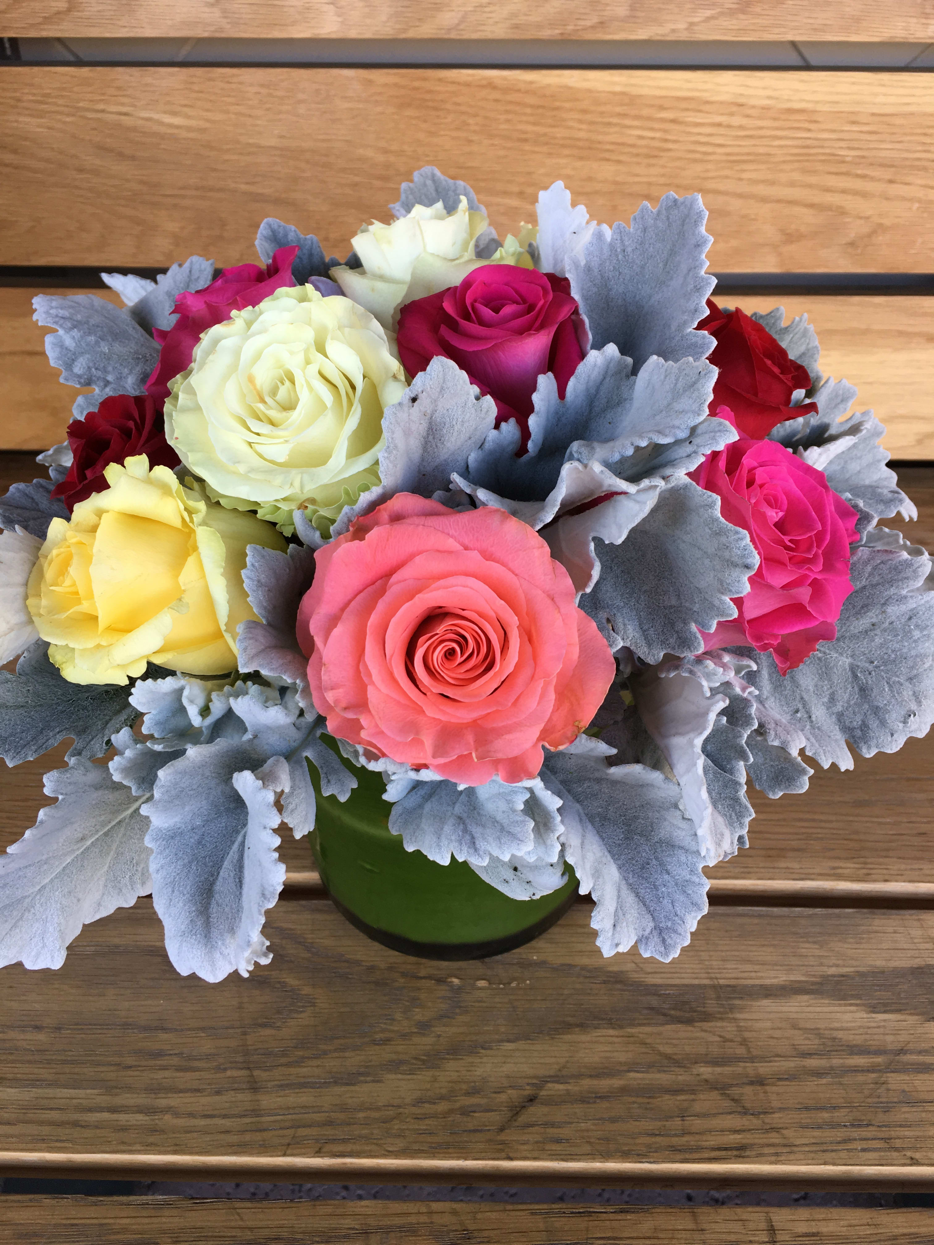 Bouquet of multicolored roses in a green vase