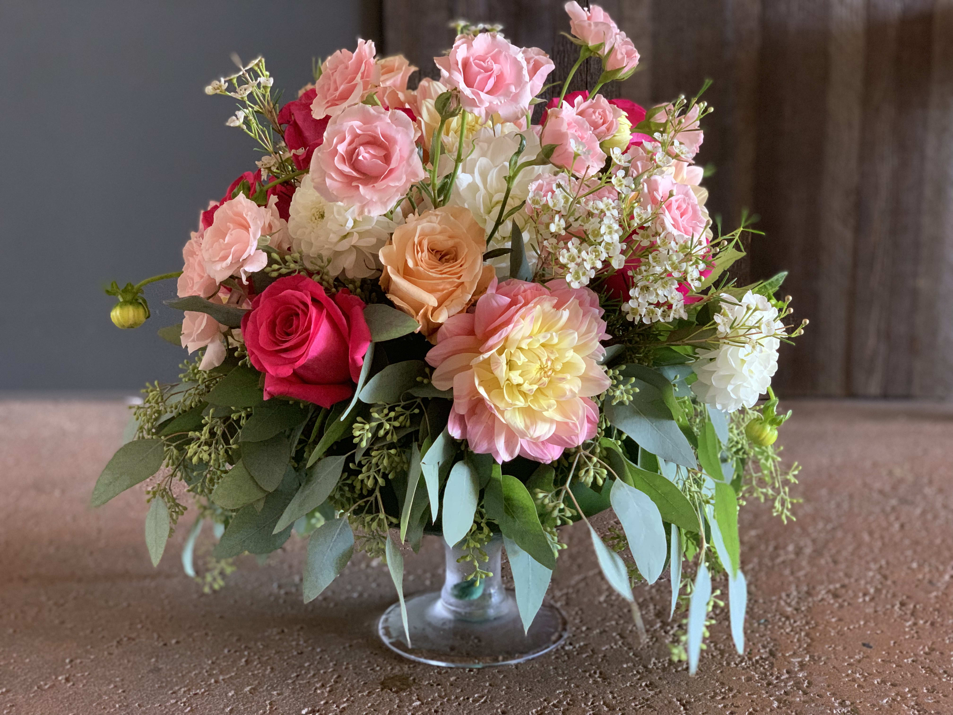 Mixed pink and peach flower arrangement in a clear glass vase