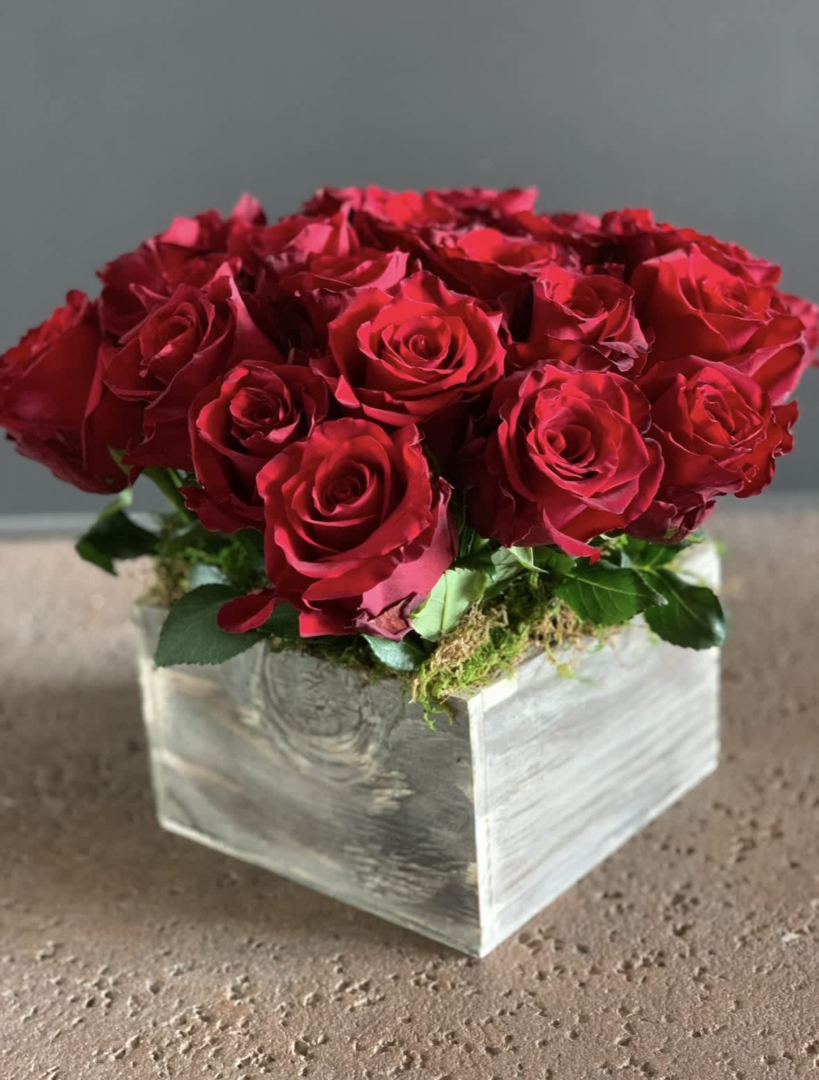 Red roses arranged in a square wooden box