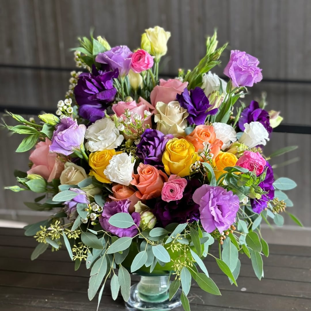 Mixed bouquet of roses and lisianthus in a glass vase