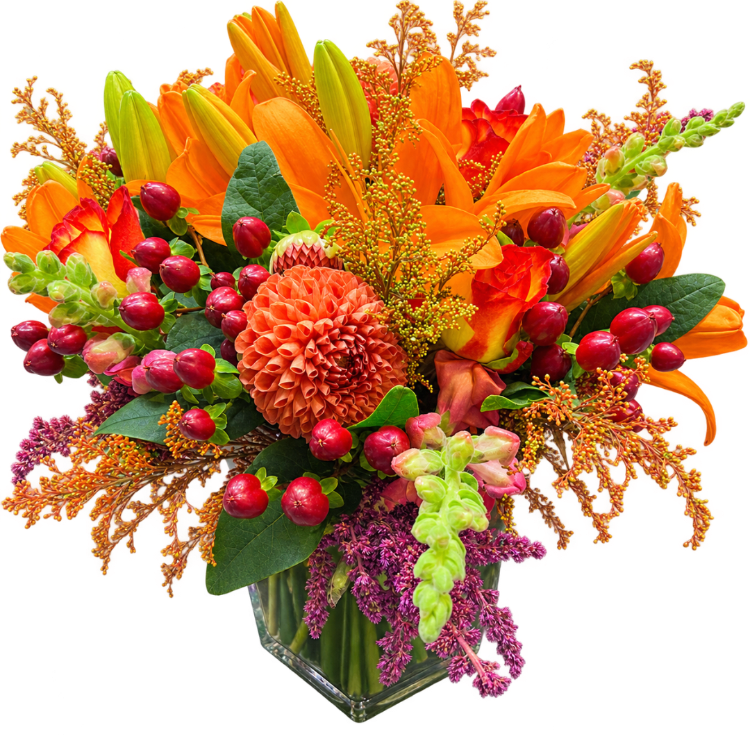 Orange and red floral arrangement in a clear glass vase