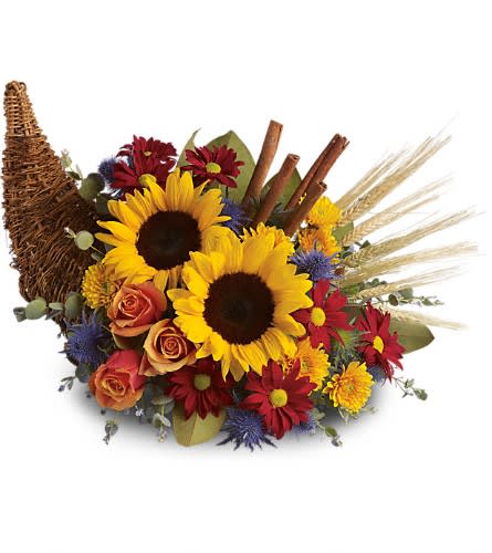 Sunflower bouquet with roses and daisies in a woven basket