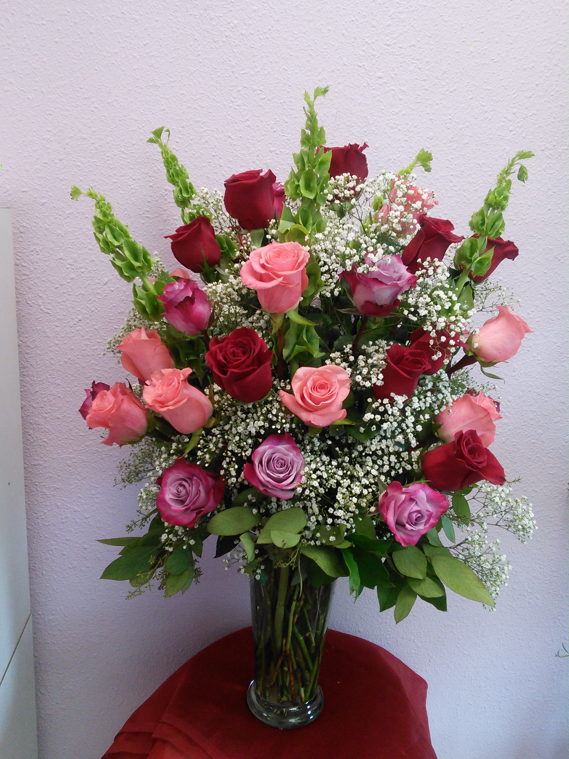 Mixed roses in a clear glass vase with baby's breath