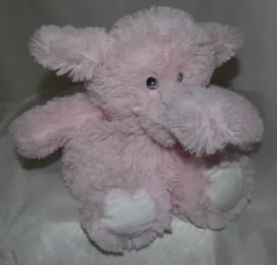 Pink plush teddy bear with white paws and black eyes