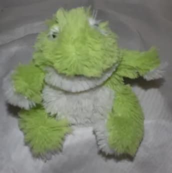 Green and white plush frog toy with fuzzy texture