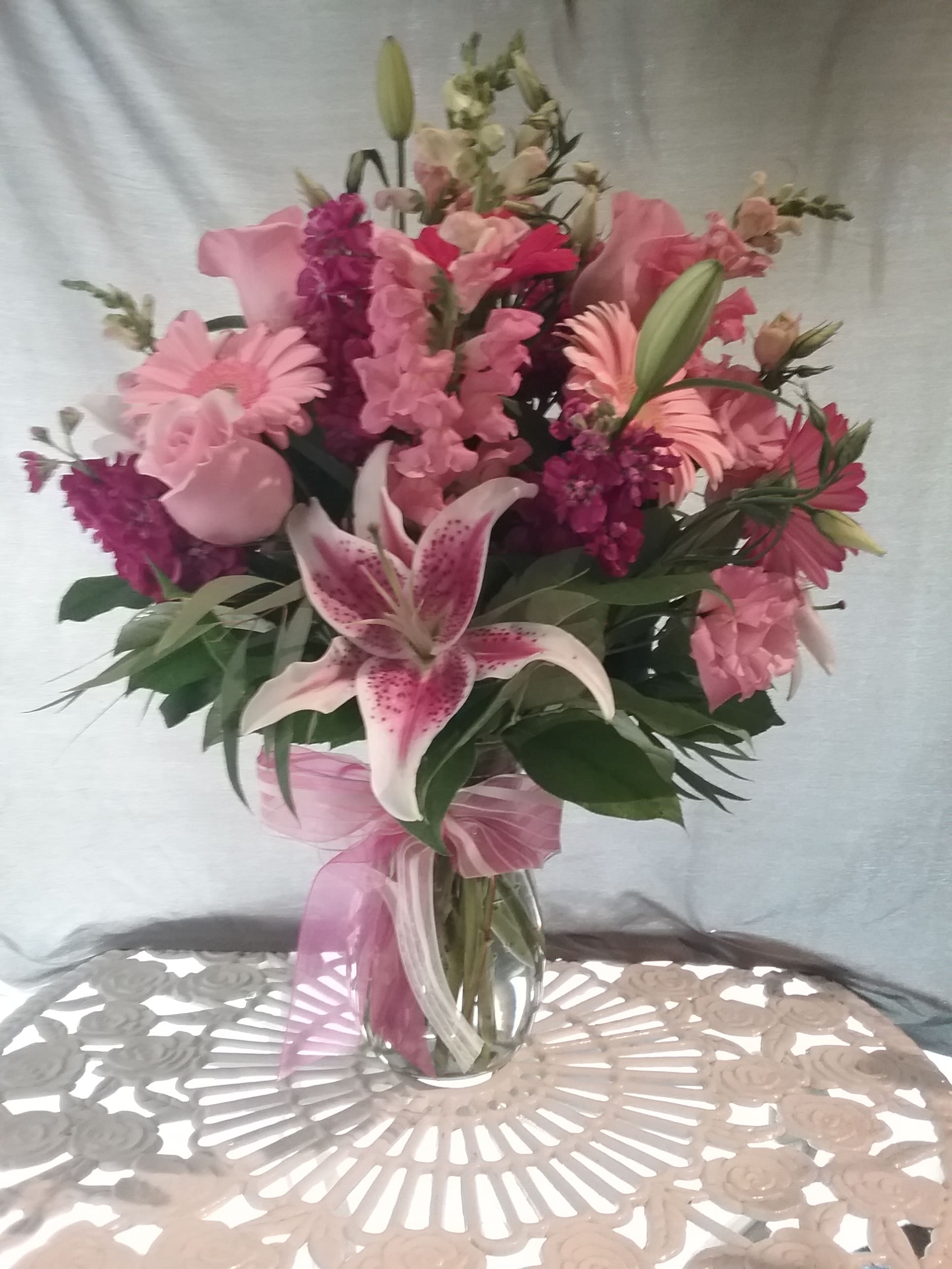 Pink mixed bouquet with lilies and roses in a glass vase