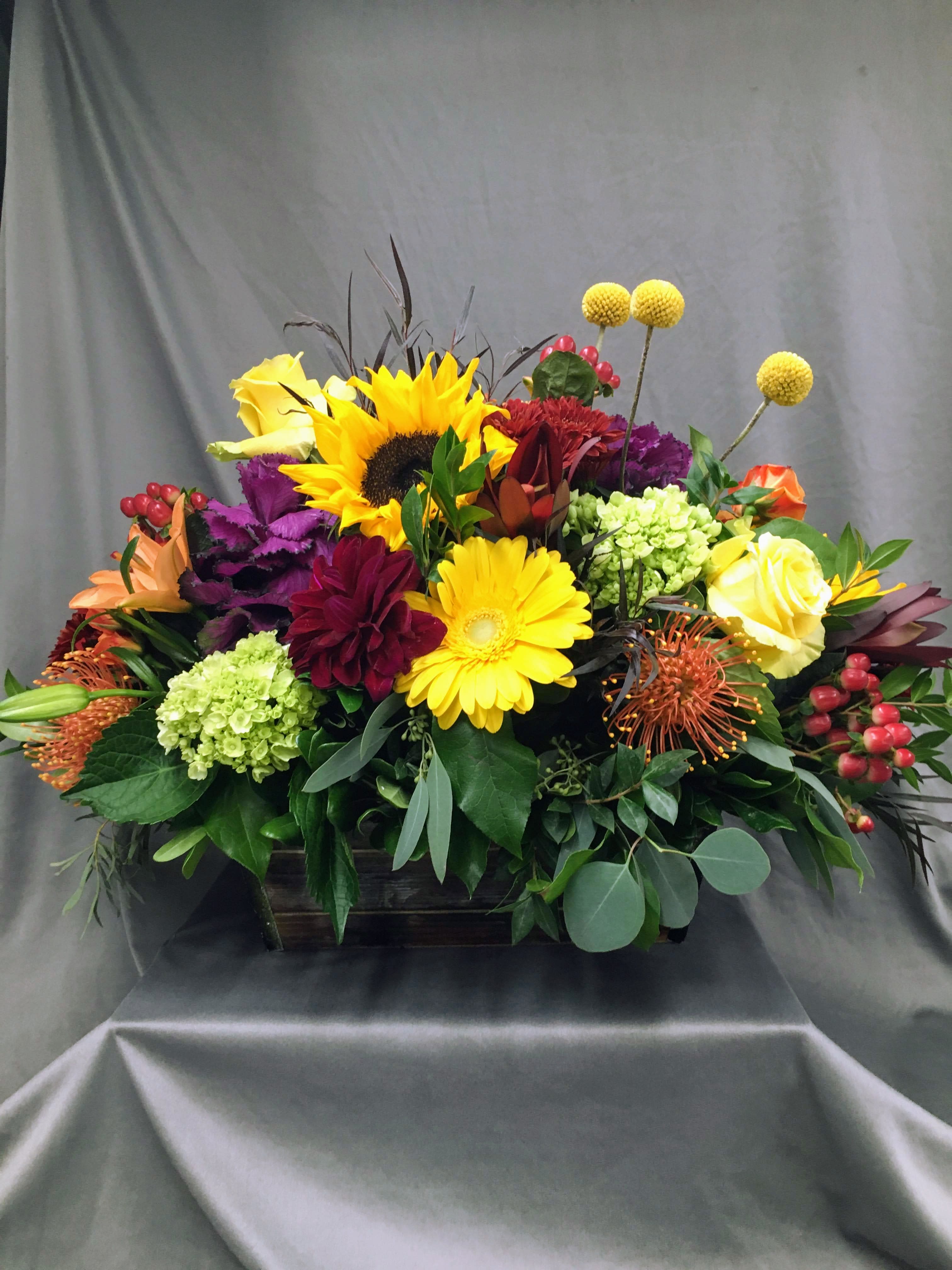 Harvest Blooms - A beautiful mixture of fall assorted flowers arranged in a rustic wooden planter box. Great as a centerpiece for a dining room table!