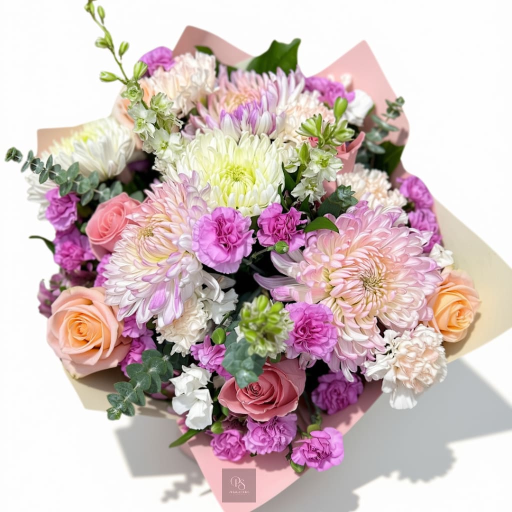 Bouquet of pink, peach, and white flowers wrapped in pastel paper