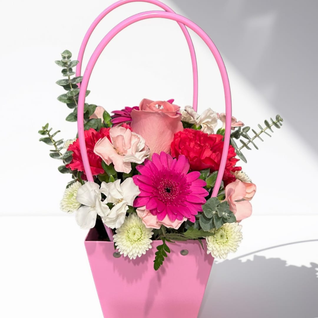 Pink basket arrangement with roses, gerbera daisies, and carnations