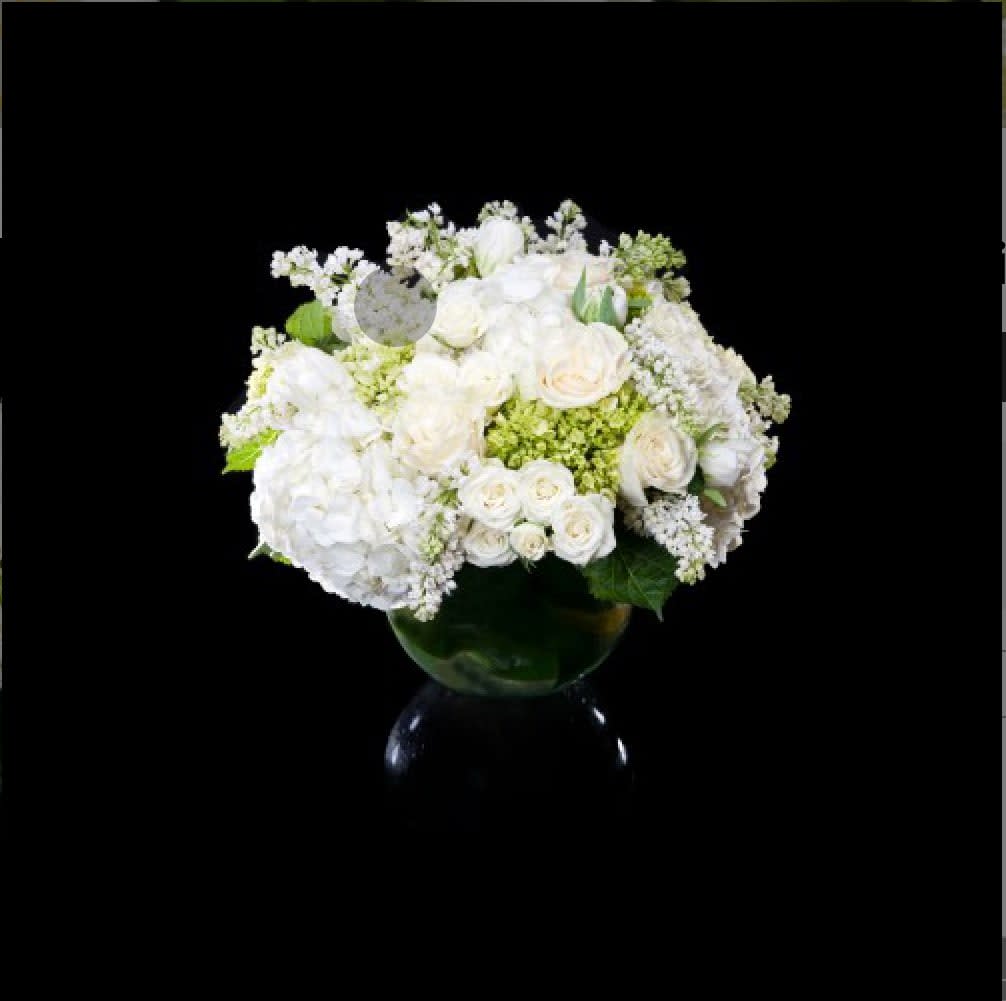 White roses and hydrangeas arranged in a glass vase