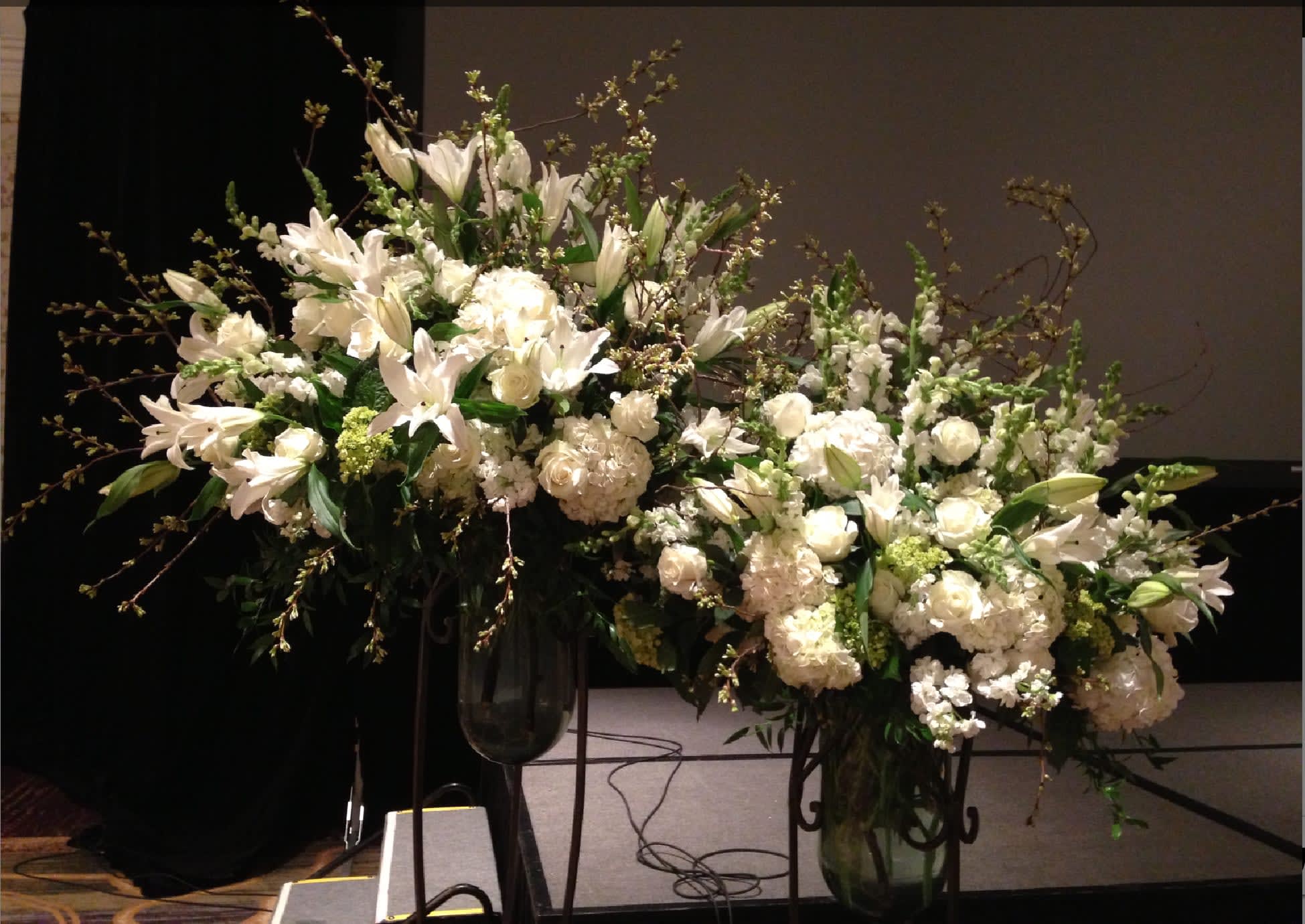 Large white floral arrangements in tall glass vases