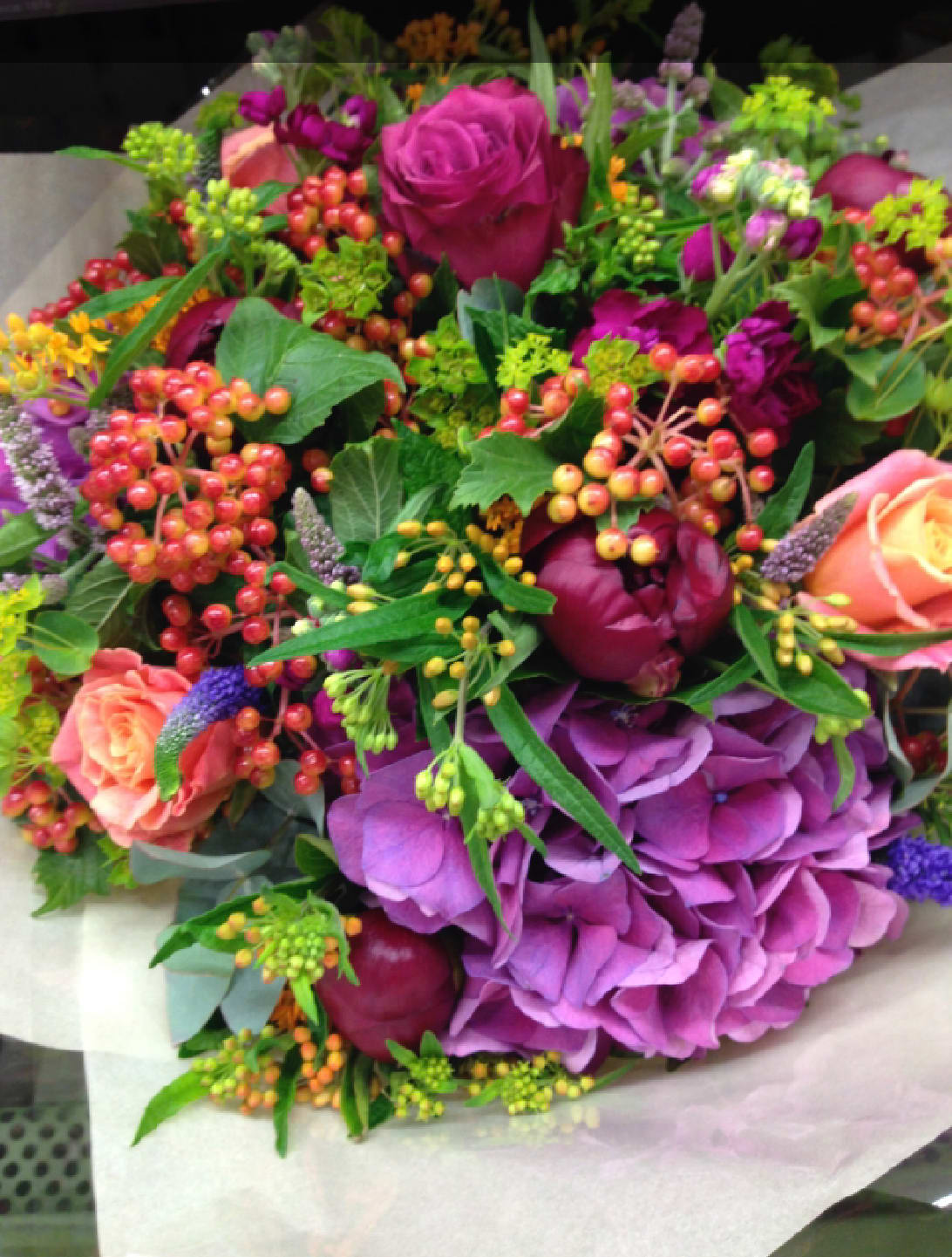 Bouquet of pink and purple flowers with berry accents