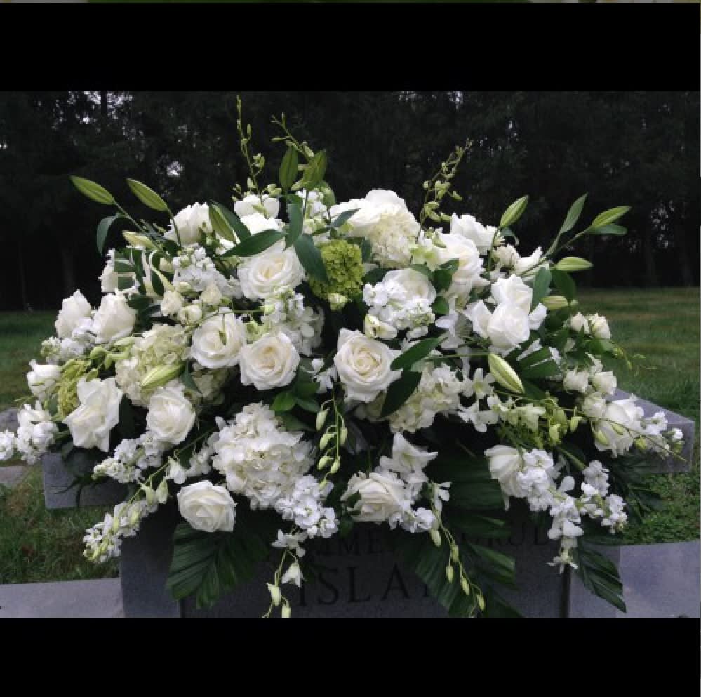 White floral casket spray with roses and lilies