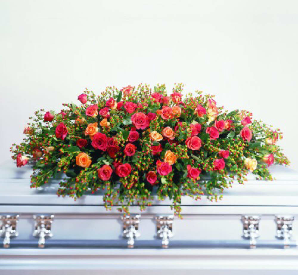 Large spray of pink and orange roses on a casket