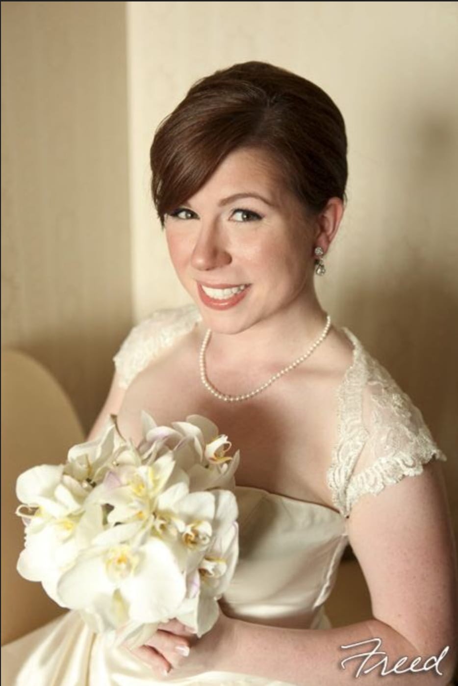 Bride holding a white orchid bouquet