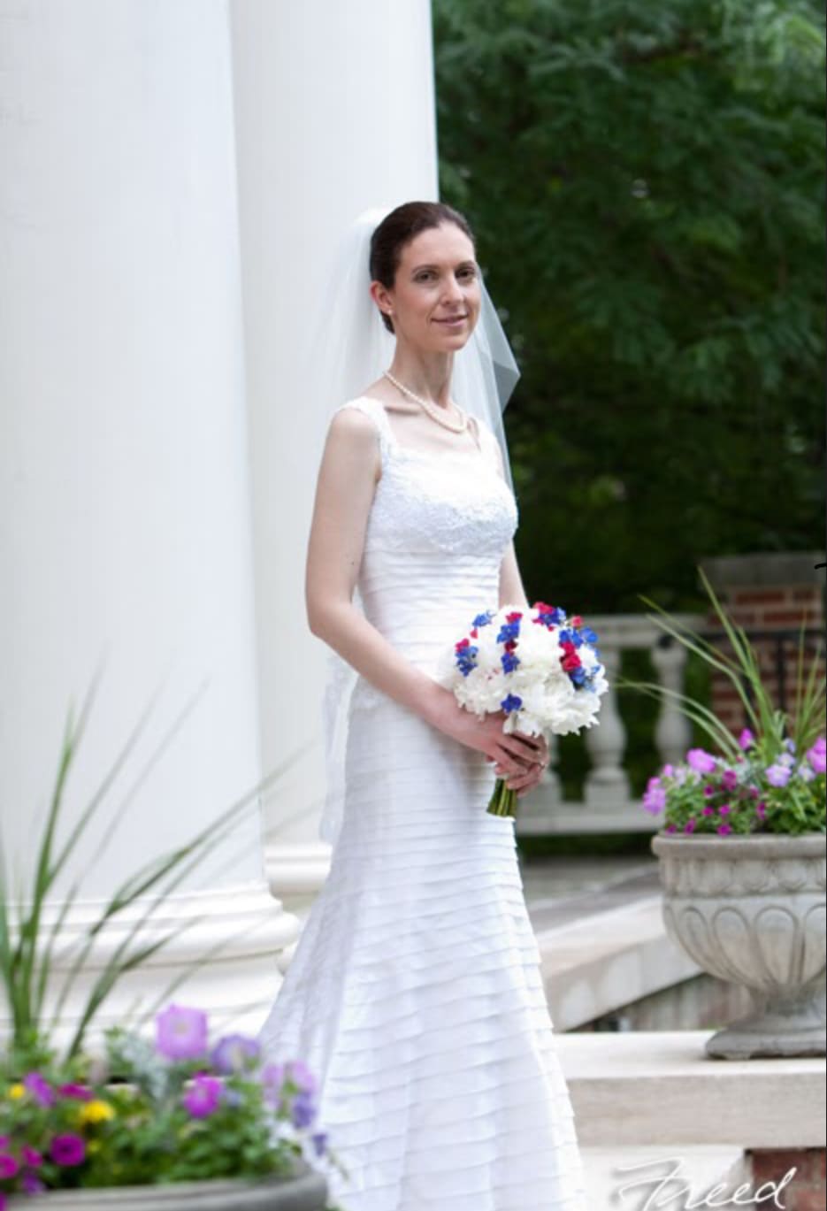 Bride in a white dress holding a white and blue bouquet