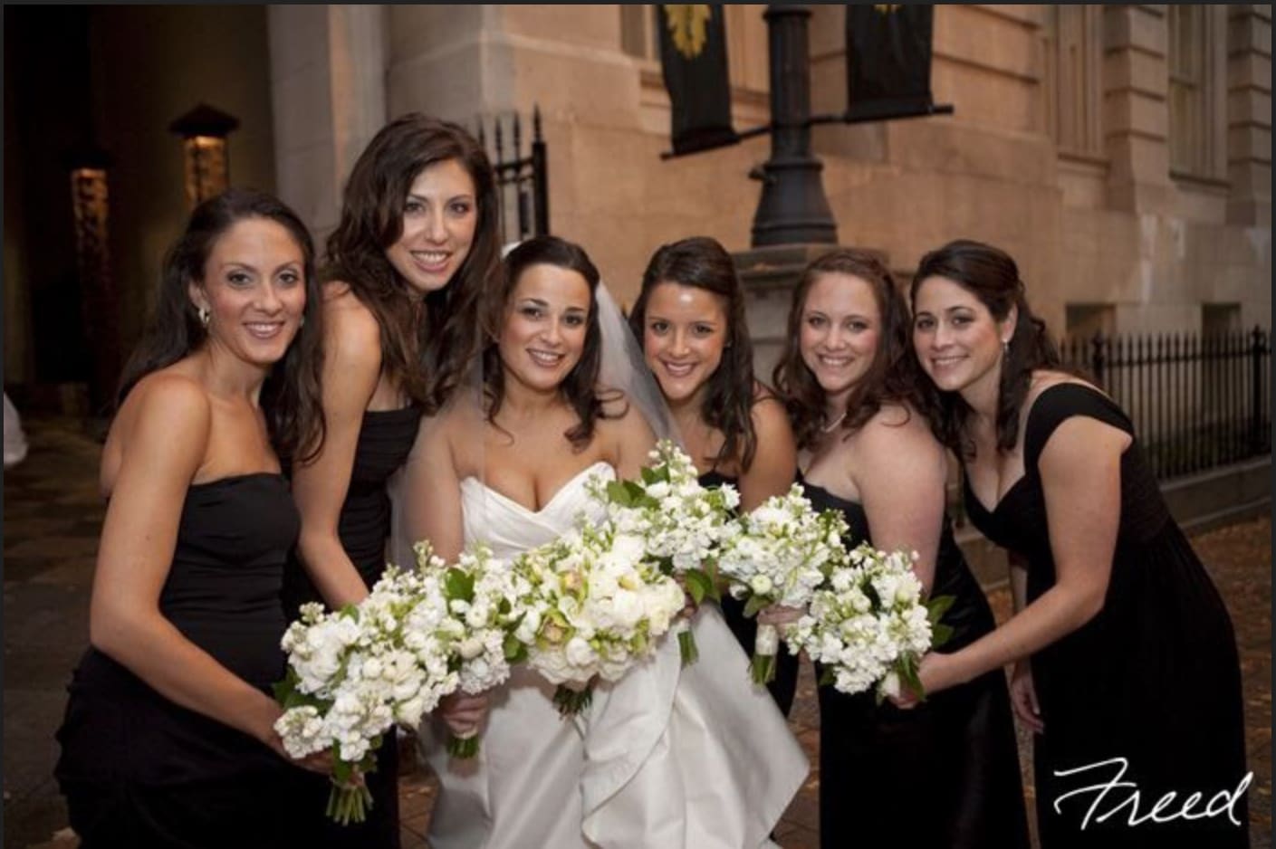 Bride and bridesmaids holding white bouquets