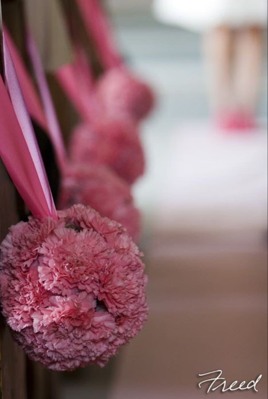 Pink carnation pomander with ribbon hanging indoors
