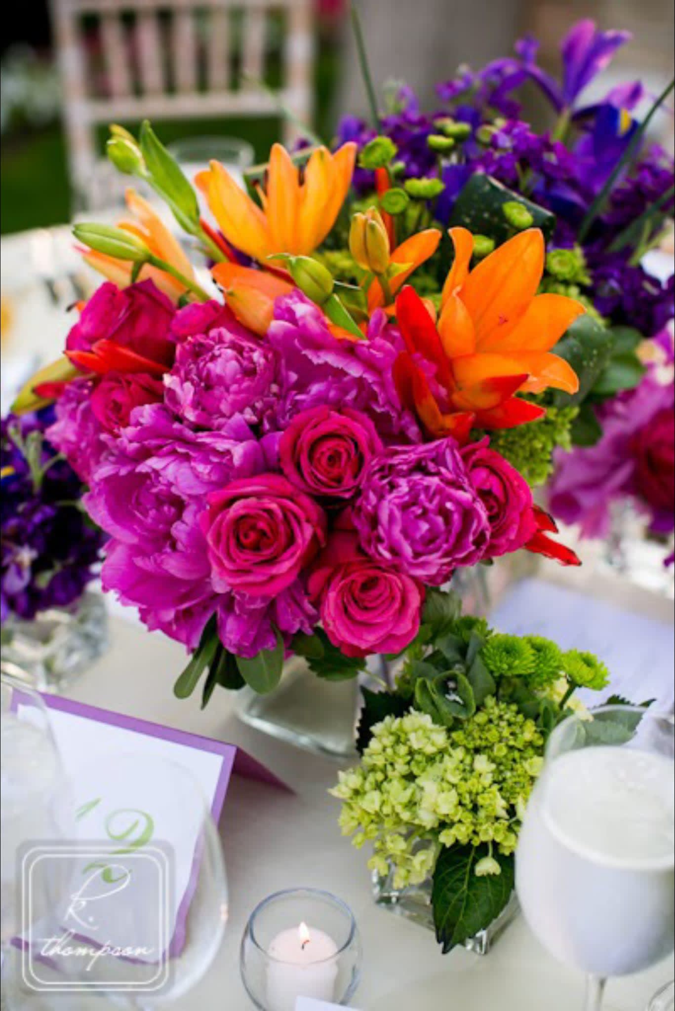 Bright mixed bouquet with pink roses, orange lilies, and purple flowers in a vase