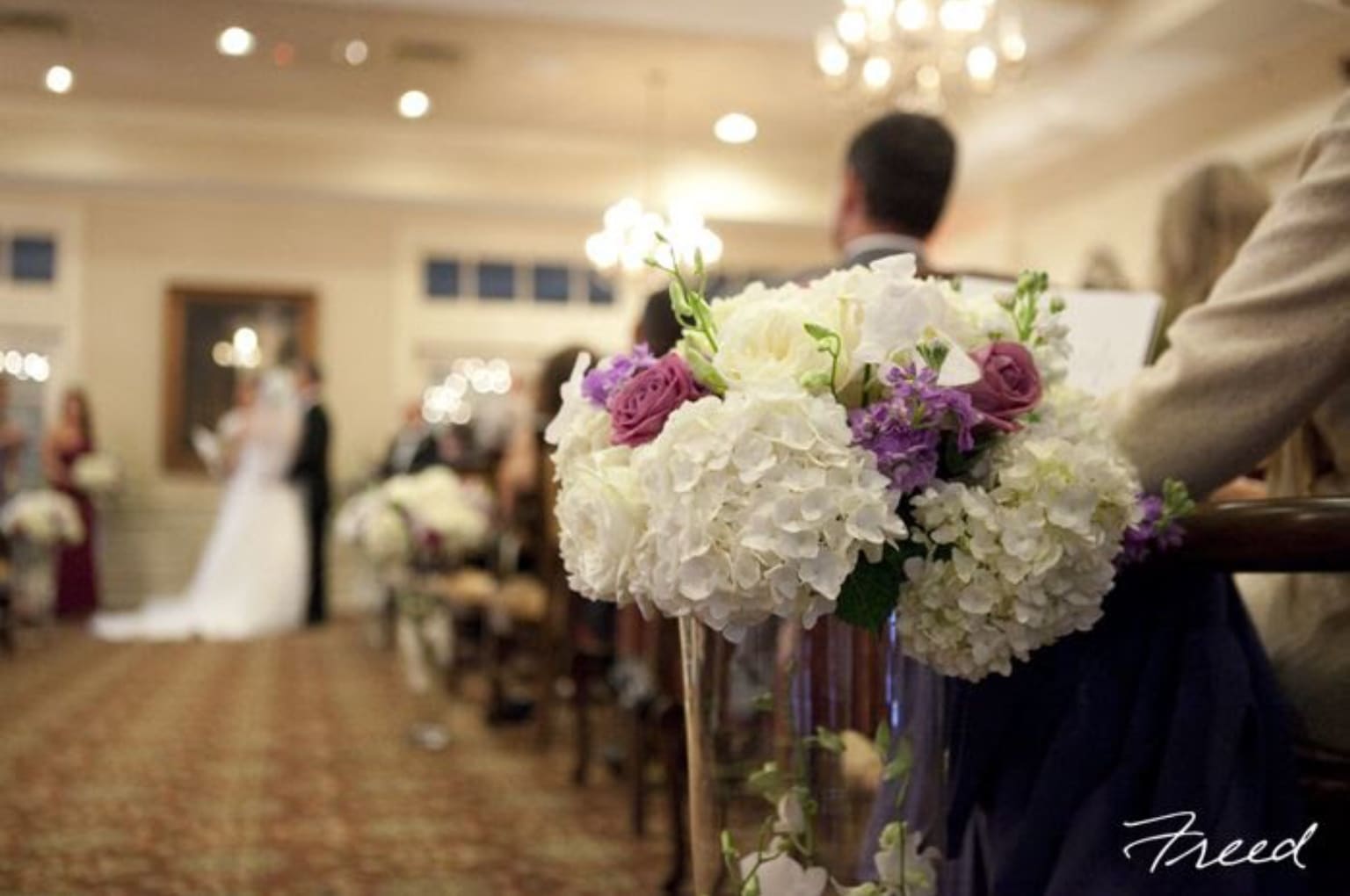 White and purple wedding bouquet in a clear vase