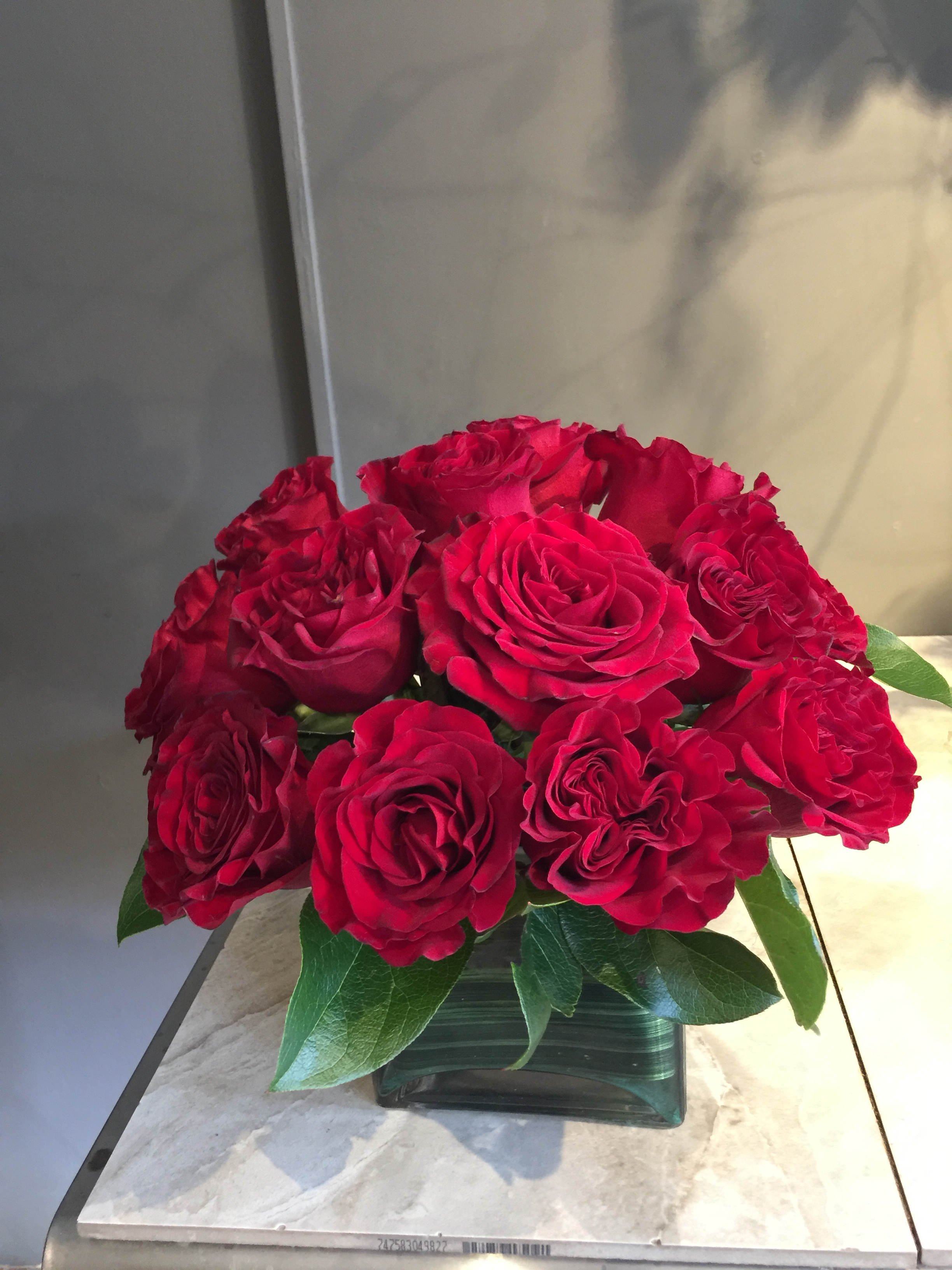 Red roses arranged in a square glass vase
