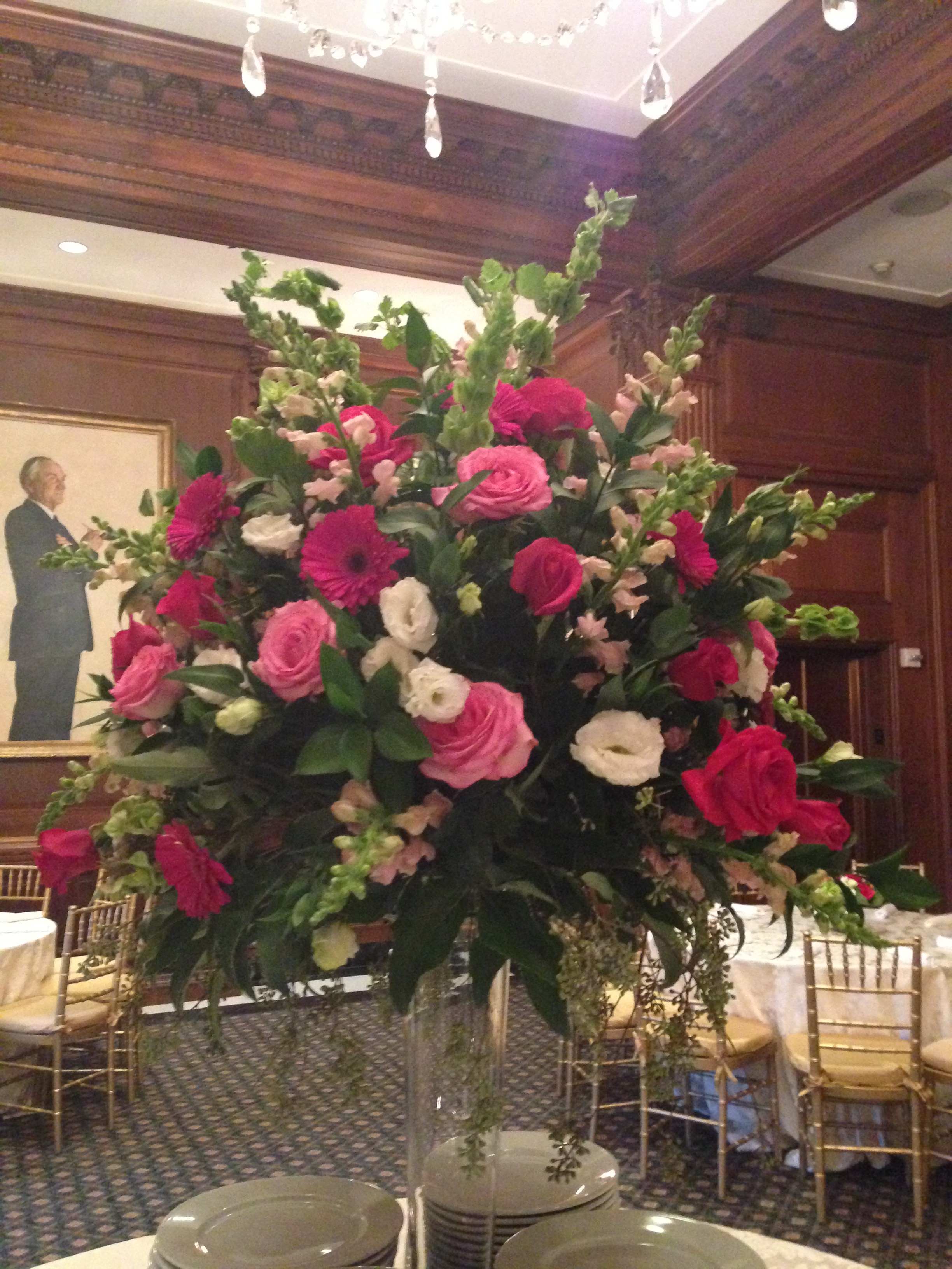 Large pink and white floral centerpiece in a clear vase