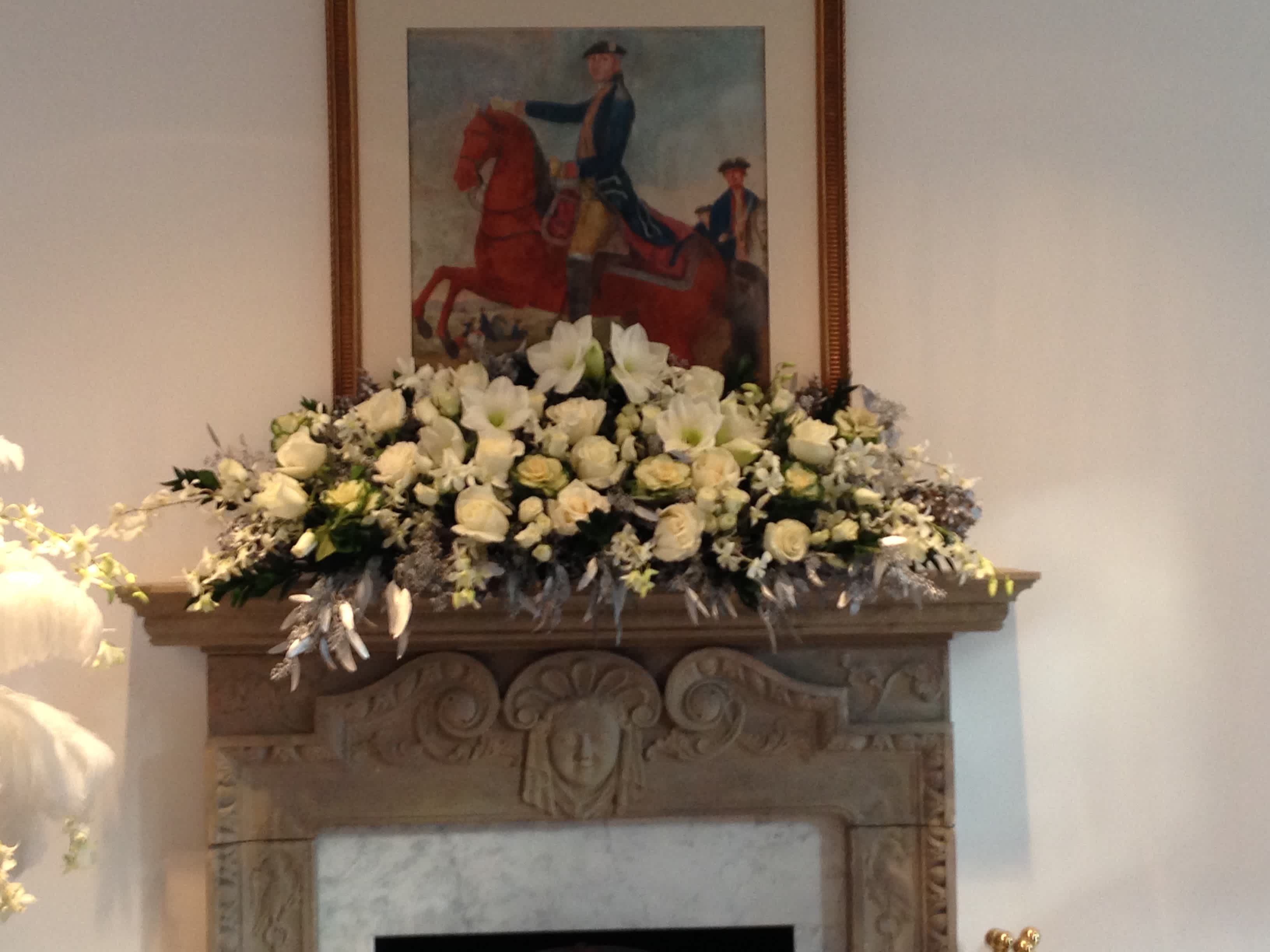 Large white floral arrangement displayed on a mantel