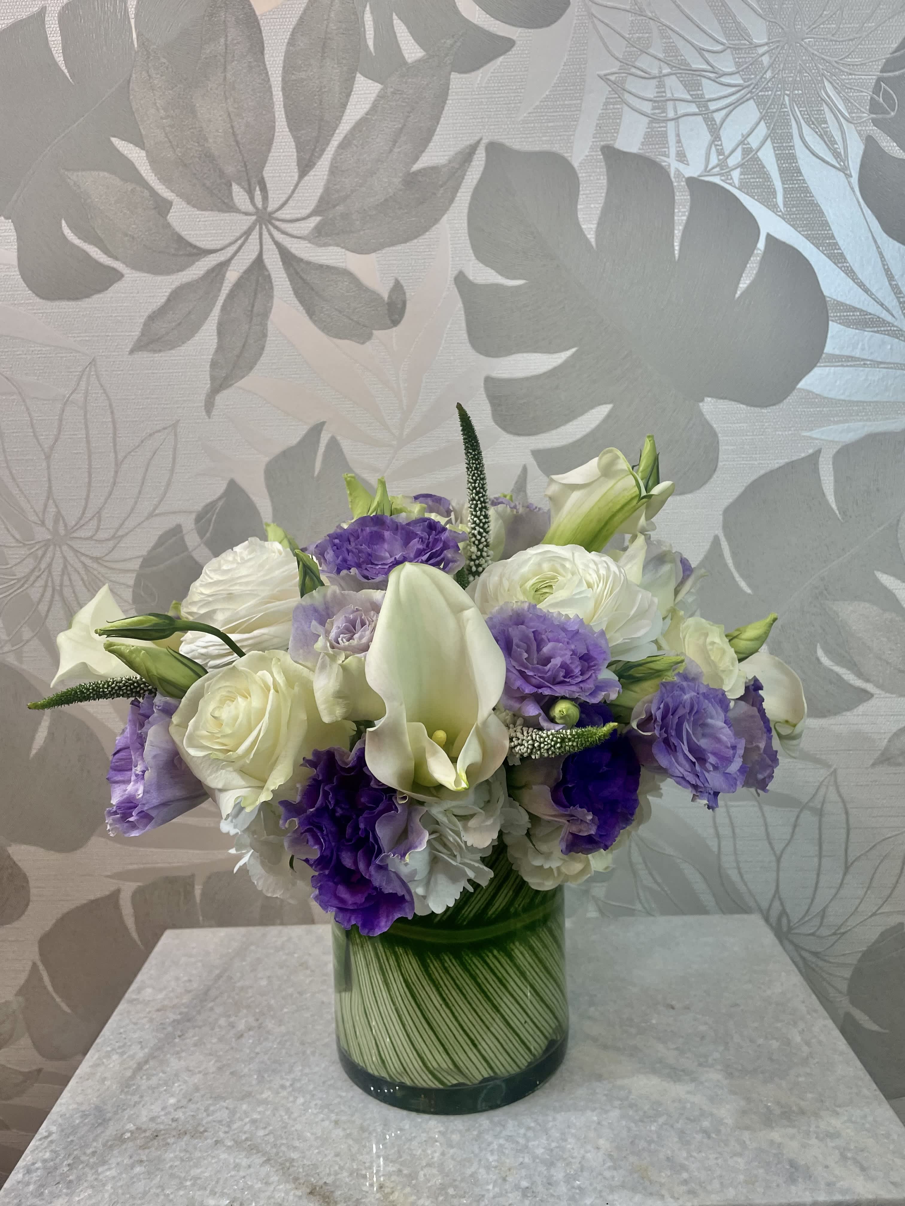 Purple and white bouquet in a glass vase