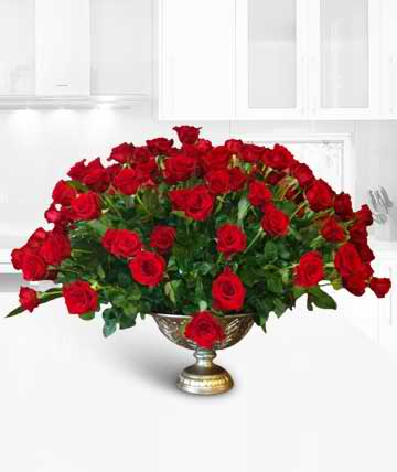Large arrangement of red roses in a gold pedestal vase