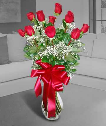 Red roses in a white vase with a large red ribbon