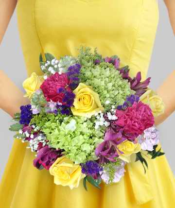 Person holding a colorful bouquet of mixed flowers