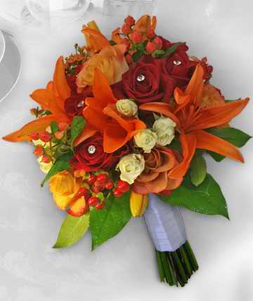 Bouquet of orange lilies and red roses with green leaves