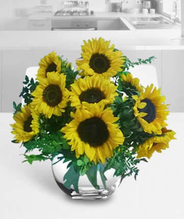 Bouquet of yellow sunflowers in a clear glass vase