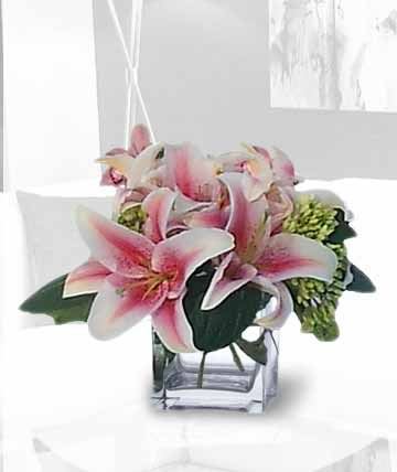 Pink lilies arranged in a clear square vase