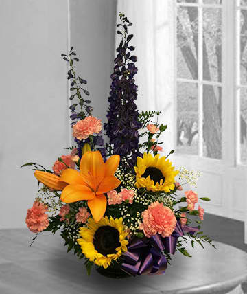 Tall floral arrangement with sunflowers, orange lilies, and pink carnations