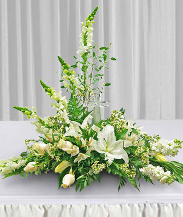 White floral centerpiece with lilies and tall snapdragons on a table