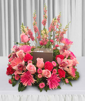 Pink floral arrangement surrounding a brown box centerpiece