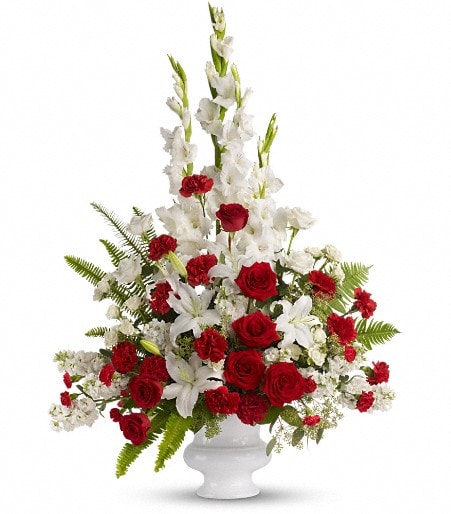 Tall red and white floral arrangement in a white vase