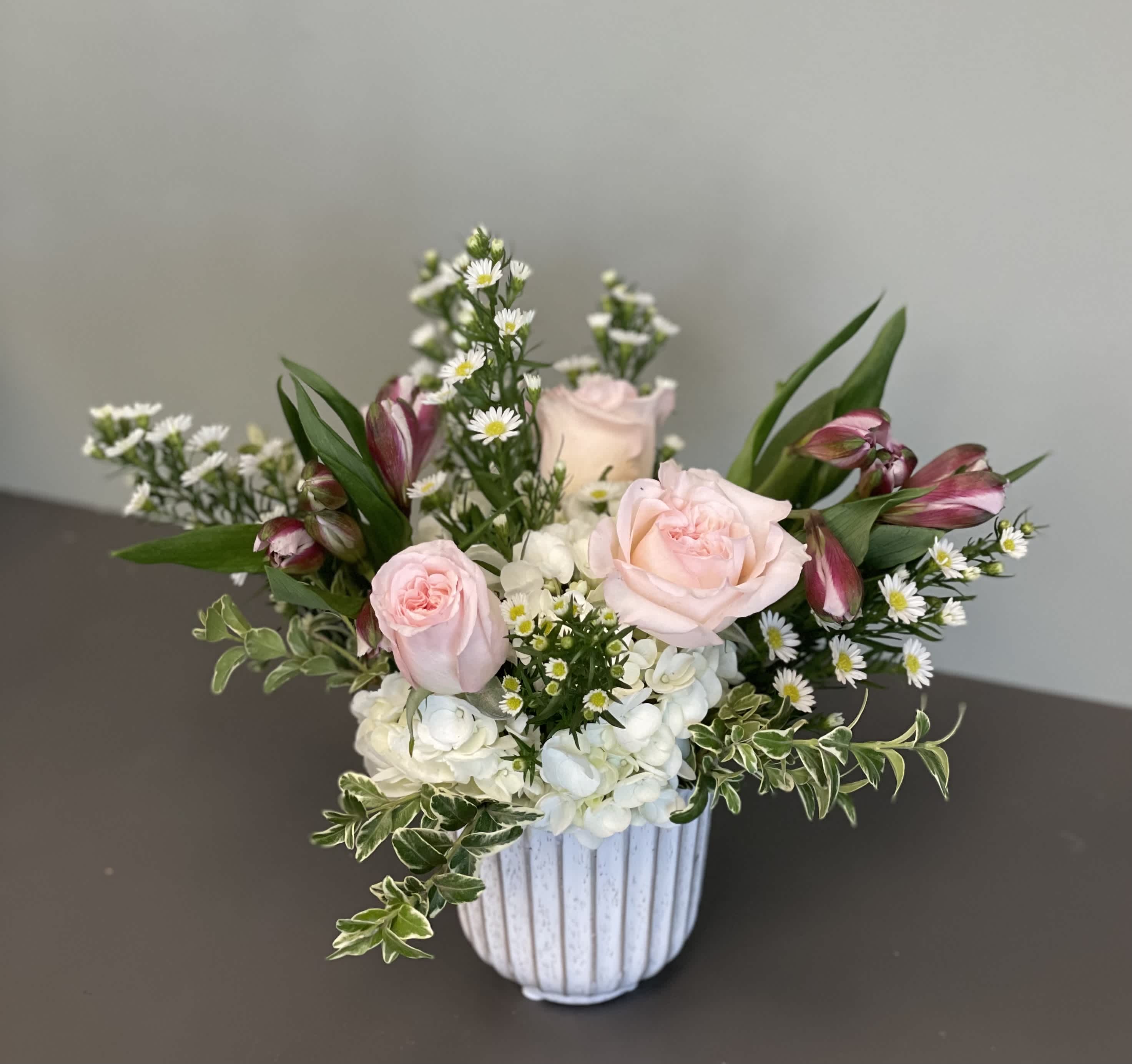 Pink roses and white hydrangeas in a white ribbed vase