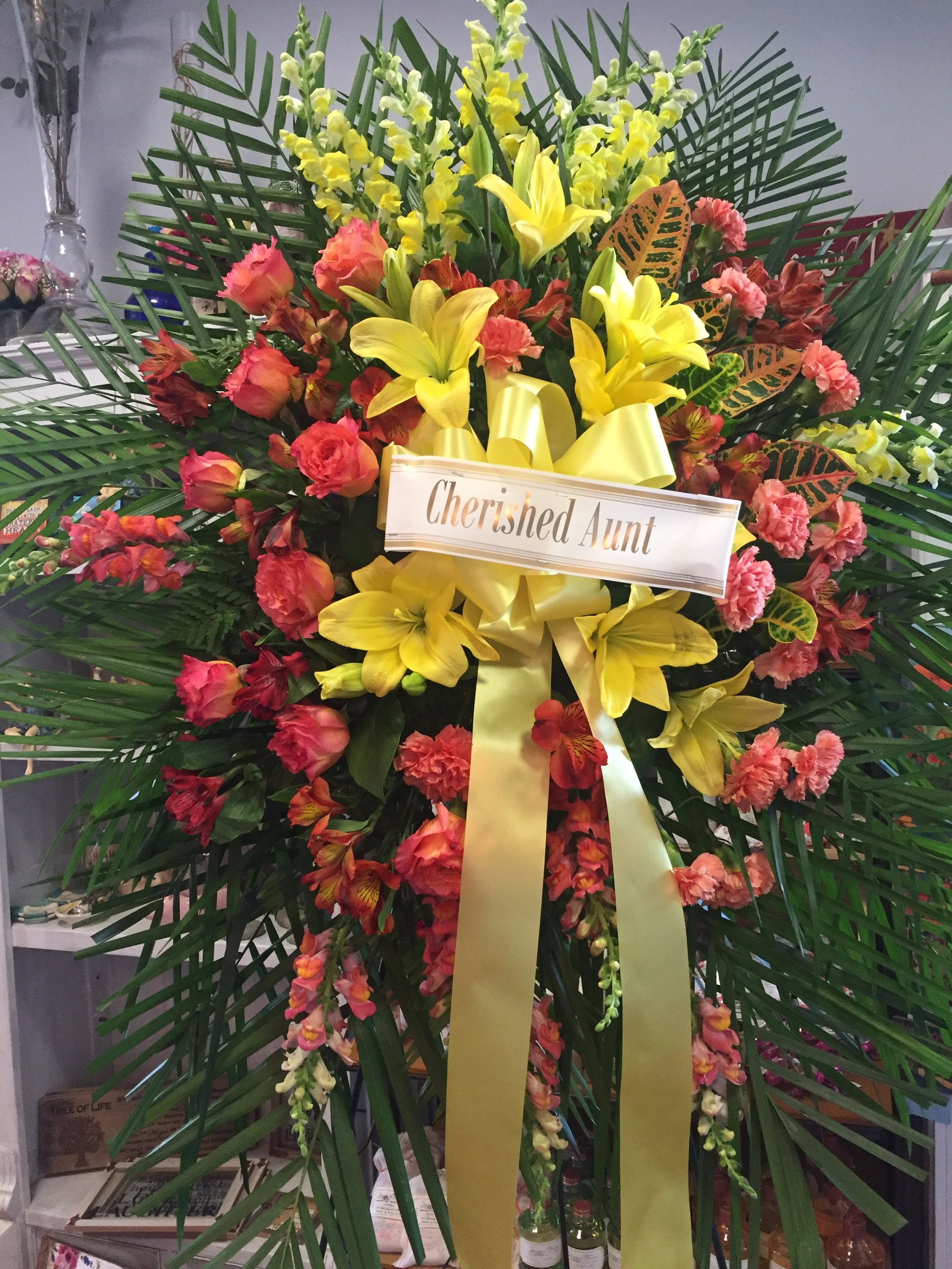 Large floral standing spray with yellow lilies and pink-orange flowers